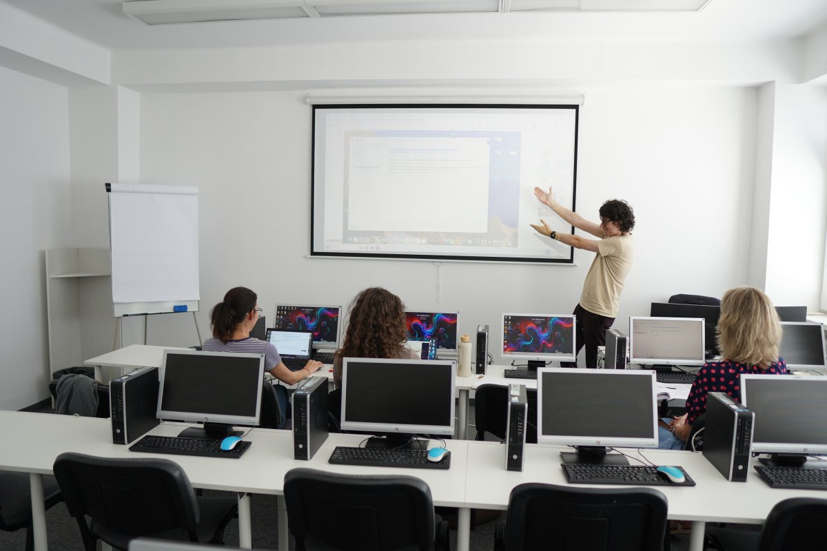 Priebeh kurzu Claude AI – učebňa s počítačmi a priebehn vyučovania na projektore
