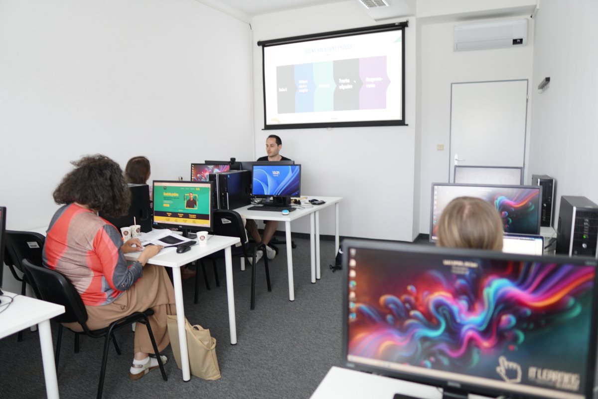 Priebeh kurzu Raketový Copywriting IV - školiteľ pred obrazovkou s prezentáciou, študenti pri počítačoch
