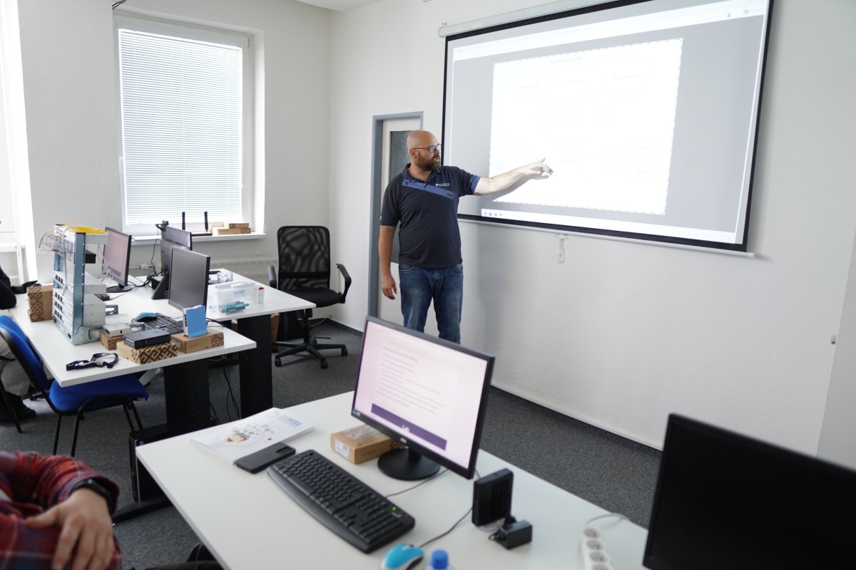 Priebeh kurzu MikroTik MTCNA v učebni s projektorom a počítačmi