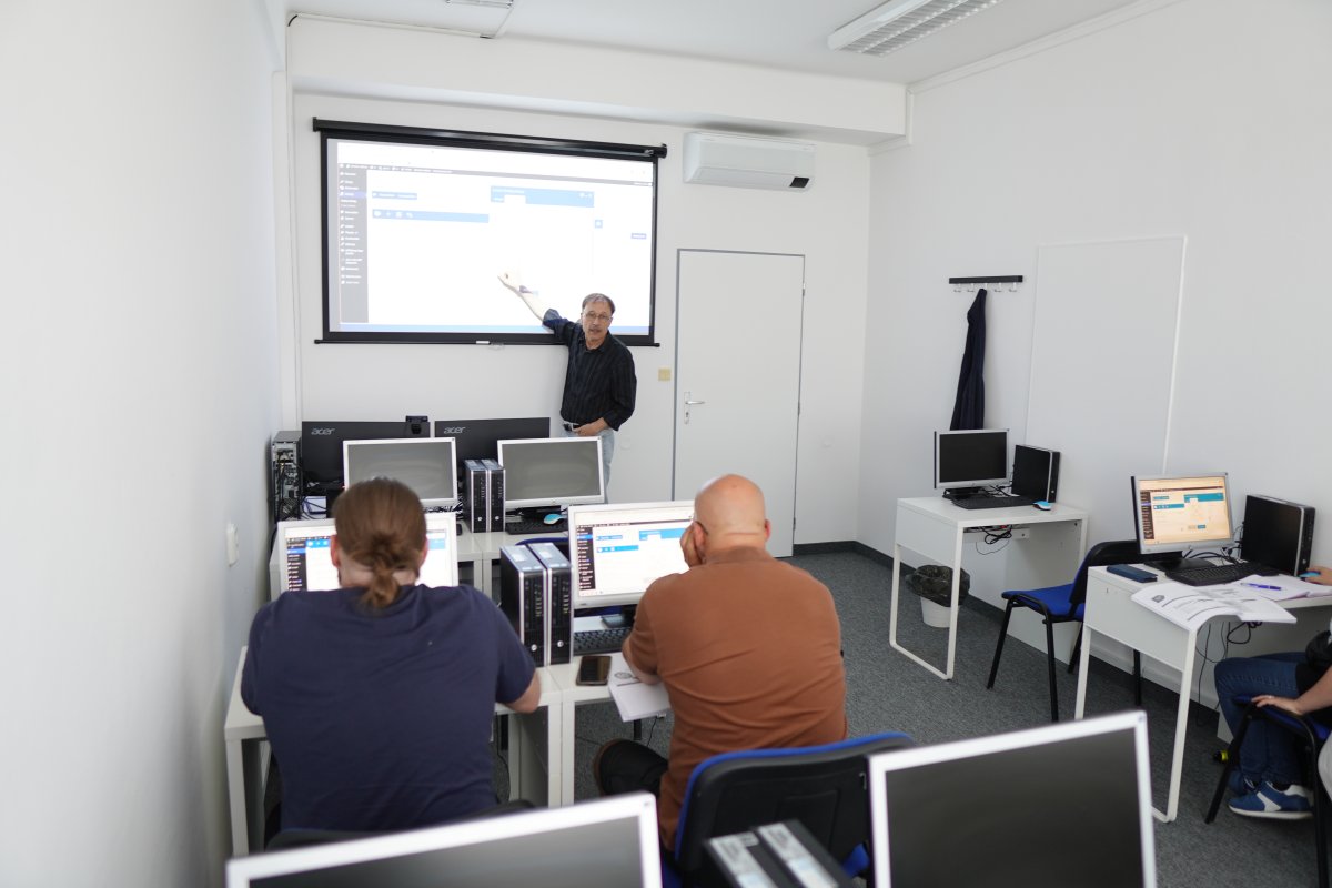 Priebeh kurzu WordPress II - učebňa s počítačmi, projektorm a prednášajúcim pri tabuľi