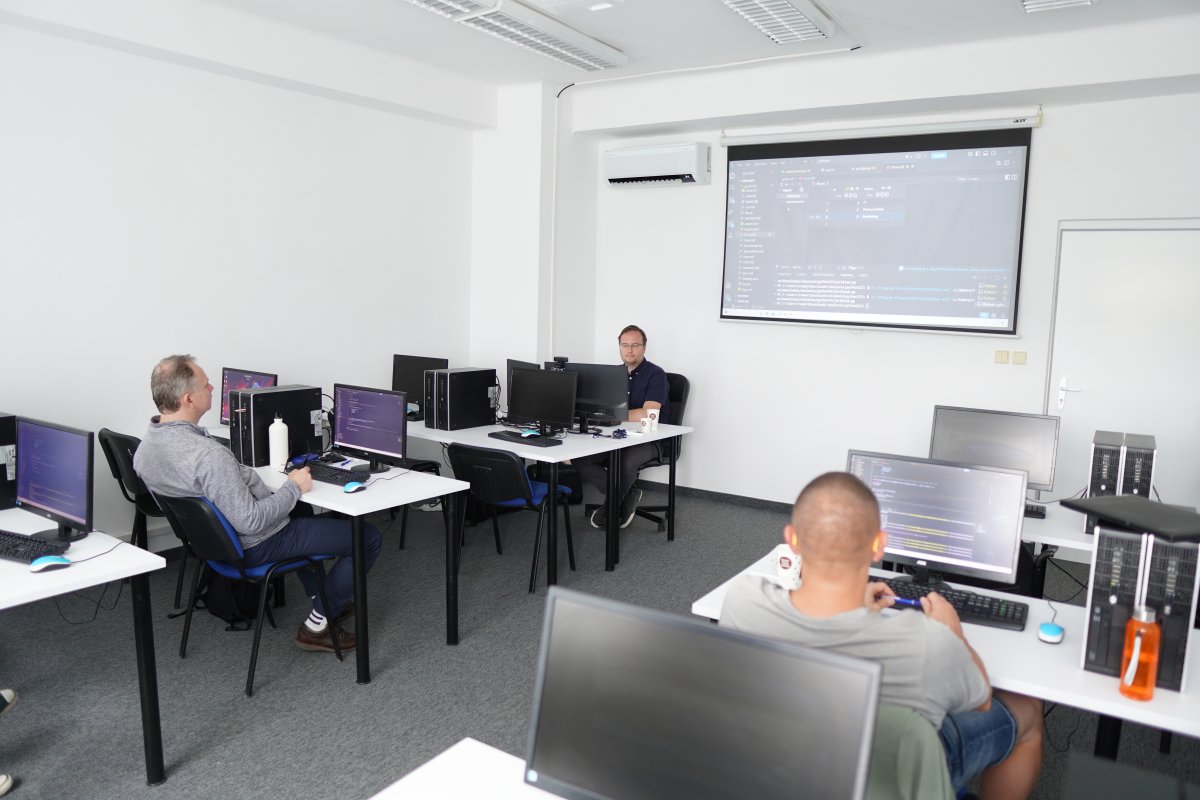 Priebeh kurzu Python III - učebňa s počítačmi a kódom na projektorovom plátne