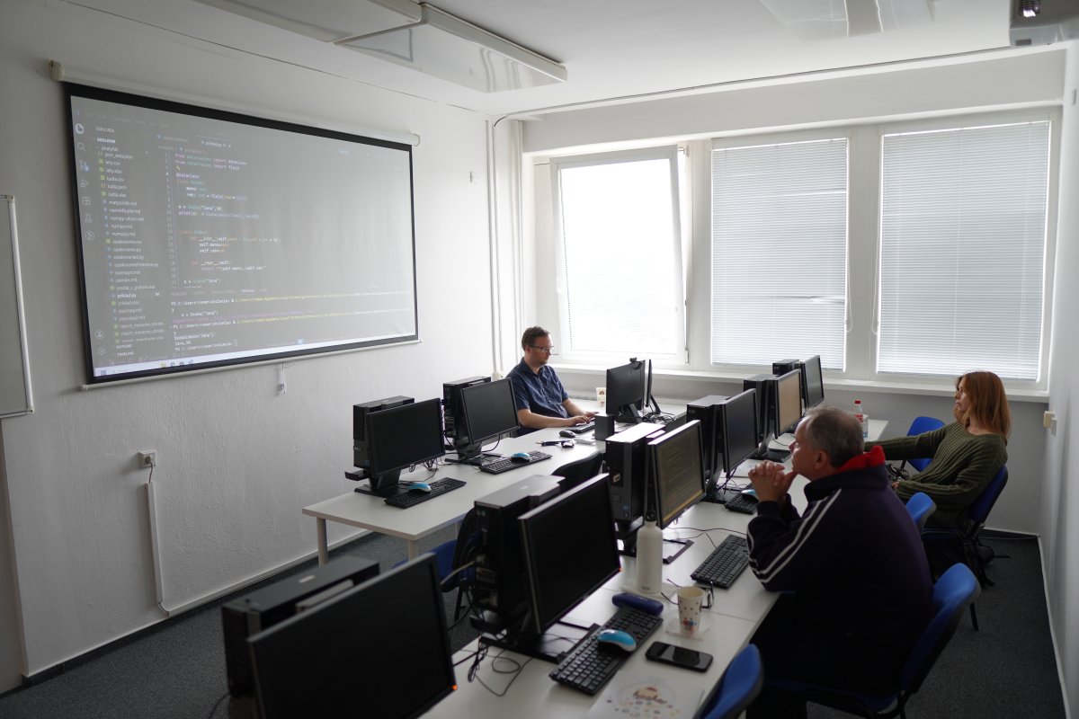 Priebeh kurzu Python dátová analýza - učebňa s počítačmi a kódovým projektom na projektorе