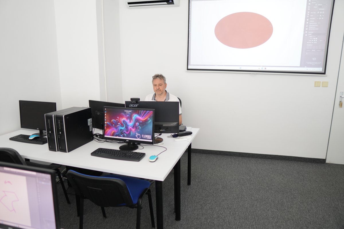 Priebeh kurzu Adobe Illustrator - prednáška v učebni s projektom vektorovej grafiky na obrazovke