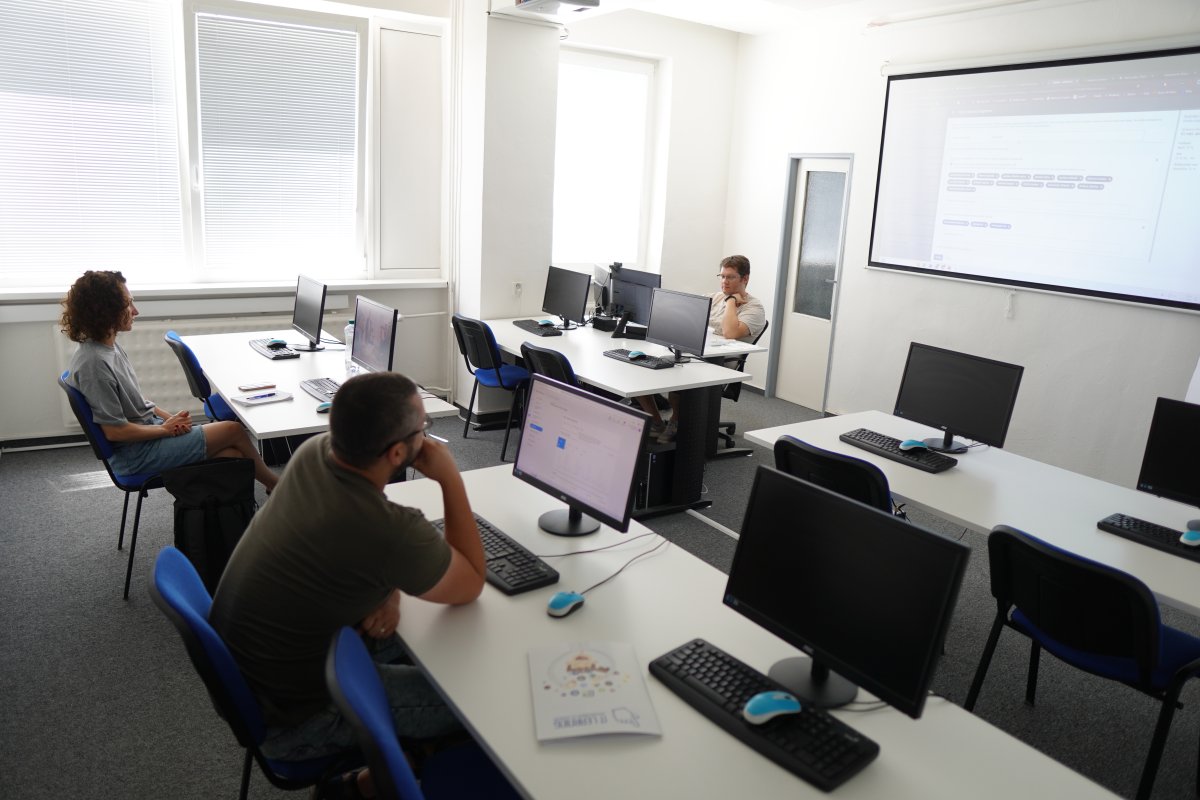 Priebeh kurzu Google Ads - počítačová učebňa s monitormi a tabuľami na pracovných stoloch