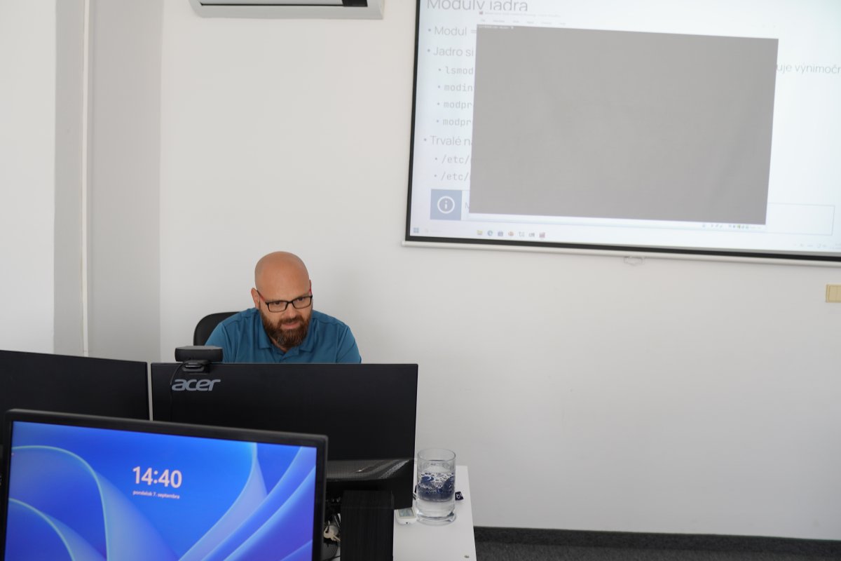 Priebeh kurzu Linux/UNIX II - vyučujúci pred obrazovkou s prezentáciou modulov jadra