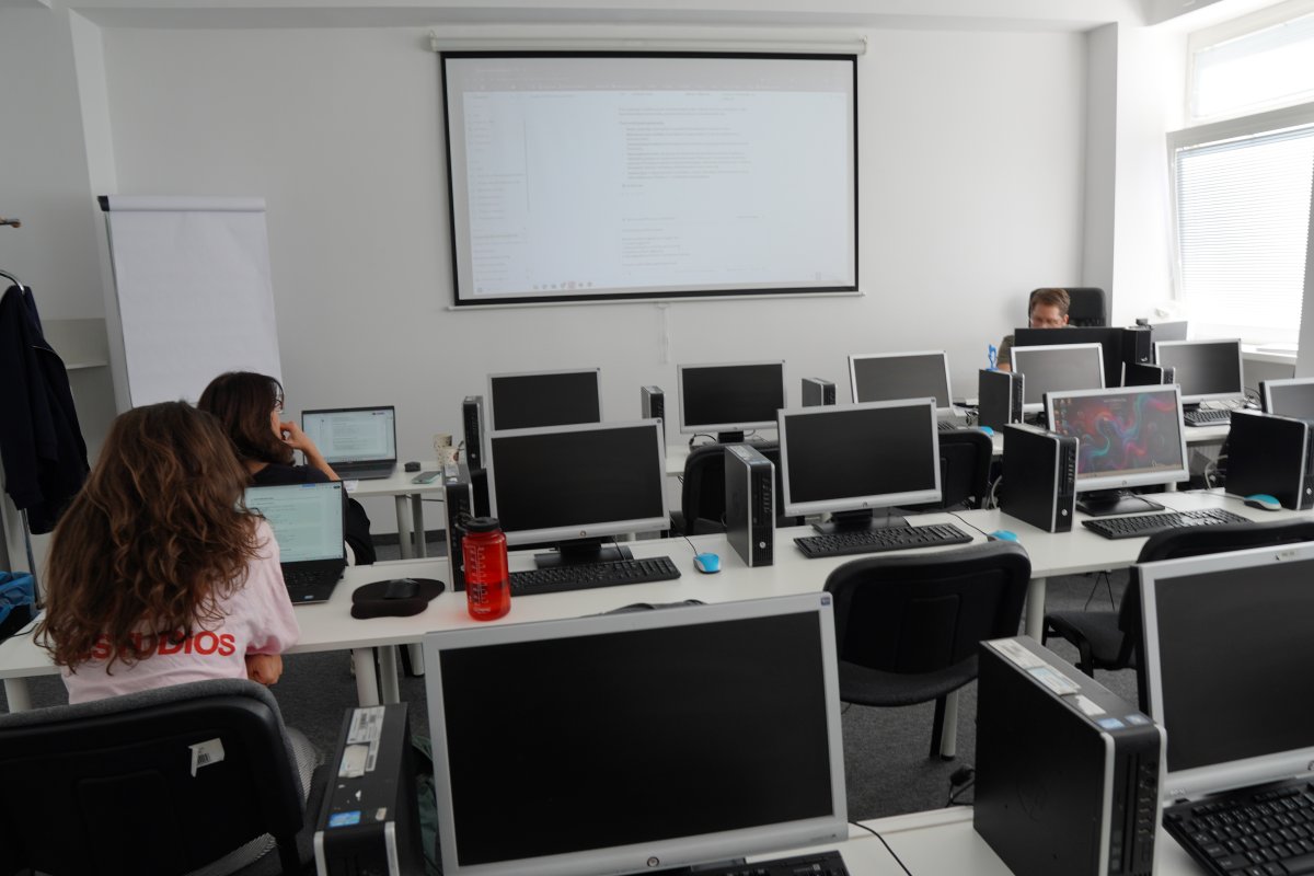 Priebeh kurzu AI v Google Ads - počítačová učebňa s monitormi a premietanou prezentáciou